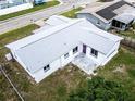 An elevated view shows the home's roof, with a back patio, white exterior, and surrounding neighborhood at 1415 Yale Dr, Holiday, FL 34691