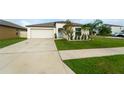 Beautiful single-story home featuring a tidy front lawn, a two-car garage, and mature landscaping at 15403 Wicked Strong St, Sun City Center, FL 33573