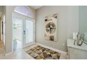 Bright foyer featuring tiled floors, arched windows, and a modern art piece at 1710 Lago Vista Blvd, Palm Harbor, FL 34685