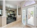 Bright home gym with mirrored wall, exercise equipment, pillars, neutral colors, and tiled floor at 1710 Lago Vista Blvd, Palm Harbor, FL 34685