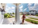 A view of neighborhood homes from under the covered front porch at 17714 Everlong Dr, Land O Lakes, FL 34638