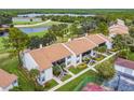 Aerial view of condos near a golf course and lake, featuring mature trees and landscaping at 1967 Cormorant Ct # 515, Clearwater, FL 33762