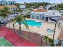Community pool and spa with tennis courts, all surrounded by lush palm trees at 1967 Cormorant Ct # 515, Clearwater, FL 33762