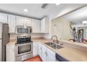 Bright kitchen featuring stainless appliances, white cabinetry, and a breakfast bar overlooking the dining area at 2007 Searay Shore Dr, Clearwater, FL 33763