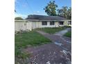 Simple one story house with overgrown landscape and weathered driveway at 2518 Mabry St, Tampa, FL 33618