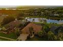 Panoramic aerial view of a beautiful home and community, nestled amongst lush greenery and a tranquil lake at 3895 Mimosa Pl, Palm Harbor, FL 34685