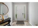Bright entryway featuring tile flooring, a console table with mirror, and a welcoming front door with sidelights at 4504 Silver Lining St, Sarasota, FL 34238