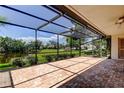 Spacious screened-in patio with brick flooring offering serene views of the pond and community at 50 Ingrid Pl # 50, Oldsmar, FL 34677