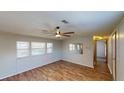 Bright living room with wood-look flooring, a ceiling fan, and plenty of natural light from the windows at 5824 Coventry Dr, Tampa, FL 33615
