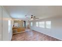 Open living area with wood-look floors, a ceiling fan, and a view into the kitchen area at 5824 Coventry Dr, Tampa, FL 33615