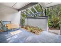 Relaxing patio space with an open-beam ceiling, bench seating, potted plants, and a tranquil view of the surrounding greenery at 70 Morning Dove Pl, Oldsmar, FL 34677