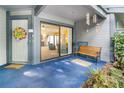 Inviting patio with an open sliding glass door that offers seamless indoor-outdoor living, plus a cozy bench and decorative elements at 70 Morning Dove Pl, Oldsmar, FL 34677
