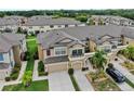Aerial view showcasing the home's roof, exterior, two-car garage, driveway, and nearby landscaping at 7849 52Nd E Ter, Bradenton, FL 34203