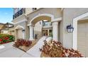 Inviting entrance features an arched entryway, columns, and lush landscaping leading to the front door at 7849 52Nd E Ter, Bradenton, FL 34203