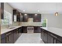 Well-appointed kitchen with dark cabinetry, sleek countertops, and mosaic tile backsplash at 834 N Oregon Ave, Tampa, FL 33606