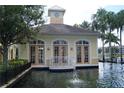 View of the community clubhouse with a tower and decorative pond at 9320 Crescent Loop Cir # 304, Tampa, FL 33619