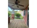 A relaxing porch with wooden floors, brick pillars, and a ceiling fan for comfortable outdoor living at 9907 Maggie St, Gibsonton, FL 33534