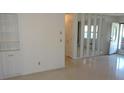Spacious living area featuring built-in shelving, terrazzo floors, and a view of the front entrance at 10871 86Th Ave, Seminole, FL 33772