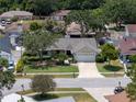 Well-maintained home with manicured lawn, mature trees, and a two-car garage in a quiet neighborhood at 12506 Twisted Oak Dr, Tampa, FL 33624