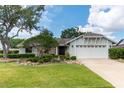 Inviting single-story home boasts a lush green lawn and a convenient two-car garage at 12506 Twisted Oak Dr, Tampa, FL 33624