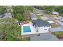 An aerial view of the home's backyard, featuring a pristine in-ground pool and surrounding greenery at 1413 E 108Th Ave, Tampa, FL 33612