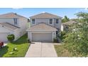 Aerial view of a two-story home with a two-car garage and a well-manicured lawn at 14403 Dunrobin Dr, Wimauma, FL 33598