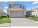 Inviting two-story home features a two-car garage, well-maintained lawn, and a concrete driveway at 14403 Dunrobin Dr, Wimauma, FL 33598