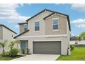 Well-maintained two-story house featuring a two-car garage, green lawn, and inviting front door at 14460 English Lavender Dr, Wimauma, FL 33598