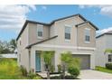 Two-story home with a two-car garage, complemented by lush landscaping and a welcoming front entrance at 14460 English Lavender Dr, Wimauma, FL 33598
