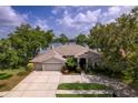 Attractive single-story home with a well-maintained lawn and three car garage at 15012 Maurine Cove Ln, Odessa, FL 33556