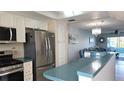 Modern kitchen featuring stainless steel appliances, light cabinets and a breakfast bar overlooking the living area at 1847 Shore Drive S # 415, South Pasadena, FL 33707