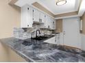 Modern kitchen features granite countertops, white cabinets, and a stylish backsplash at 1881 Lichen Ln # B, Clearwater, FL 33760
