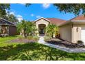 Inviting front entrance with lush landscaping, walkway, and double doors at 19104 Cellini Pl, Lutz, FL 33558