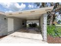 Carport showcasing a covered parking area with concrete block wall and adjacent entrance at 212 Gay Rd, Seffner, FL 33584