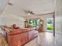 Inviting living room features hardwood floors, comfortable seating, and a TV displaying a serene beach scene at 2160 Ne Coachman Rd, Clearwater, FL 33765