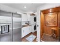 Modern laundry room equipped with a stainless steel refrigerator, washer/dryer, elevator and ample storage at 3 Pointe Way, Placida, FL 33946