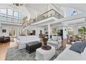 Bright, open-concept living room with high ceilings, spiral staircase and views to the kitchen at 3 Pointe Way, Placida, FL 33946