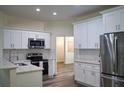 Modern kitchen featuring white cabinets, stainless steel appliances, and beautiful countertop and backsplash at 3405 Silver Glen Ct, Plant City, FL 33566