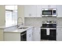 Updated kitchen featuring white cabinets, stainless steel appliances, stone countertops, and a sleek design at 3405 Silver Glen Ct, Plant City, FL 33566