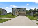 Inviting two-story home boasts a spacious driveway, two-car garage, and a meticulously kept front lawn at 34797 Rainville Loop, Zephyrhills, FL 33541