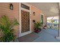 Close-up of paneled front door with modern number and door furniture, and a cozy porch swing at 409 E Frances Ave, Tampa, FL 33602