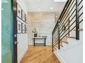 Bright entryway with hardwood floors, stone accent wall, modern staircase, and stylish decor at 443 Lucerne Ave, Tampa, FL 33606