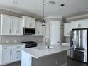 Modern kitchen with white cabinets, stainless steel appliances, and a center island at 4510 Big Woods Way, Parrish, FL 34219