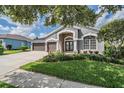 Beautiful one story home with a three car garage, mature trees and green grass at 5141 Riva Ridge Dr, Wesley Chapel, FL 33544