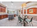 Bright open kitchen and dining area with stainless appliances, island and tile floors at 5141 Riva Ridge Dr, Wesley Chapel, FL 33544