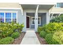 Home entrance with covered porch and manicured landscaping at 5170 Sea Mist Ln, Wesley Chapel, FL 33545