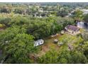 Aerial view showing a home and shed, nestled among mature trees near a winding river at 5832 Portal Rd, New Port Richey, FL 34655