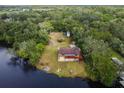 Aerial view of a two-story waterfront home with a deck overlooking the tranquil river at 5832 Portal Rd, New Port Richey, FL 34655