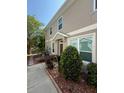 Well-kept townhouse exterior with tidy landscaping, a covered entryway, and large windows at 7543 Red Mill Circle Cir, New Port Richey, FL 34653