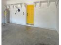 Spacious garage with white block walls, open shelving, and bright yellow door at 7543 Red Mill Circle Cir, New Port Richey, FL 34653